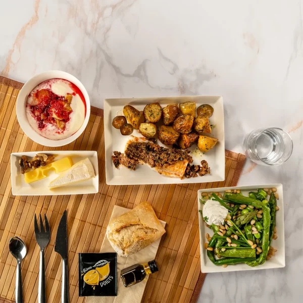 Plateau repas au poisson blanc en croûte de tapenade noire, asperges et fèves à la ricotta, duo de fromages et panna cotta à la rhubarbe, à déguster chaud ou à température ambiante